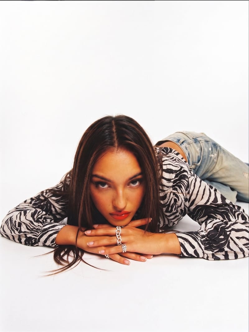 The Zola Track Jacket, lying on the studio floor and looking straight into the camera